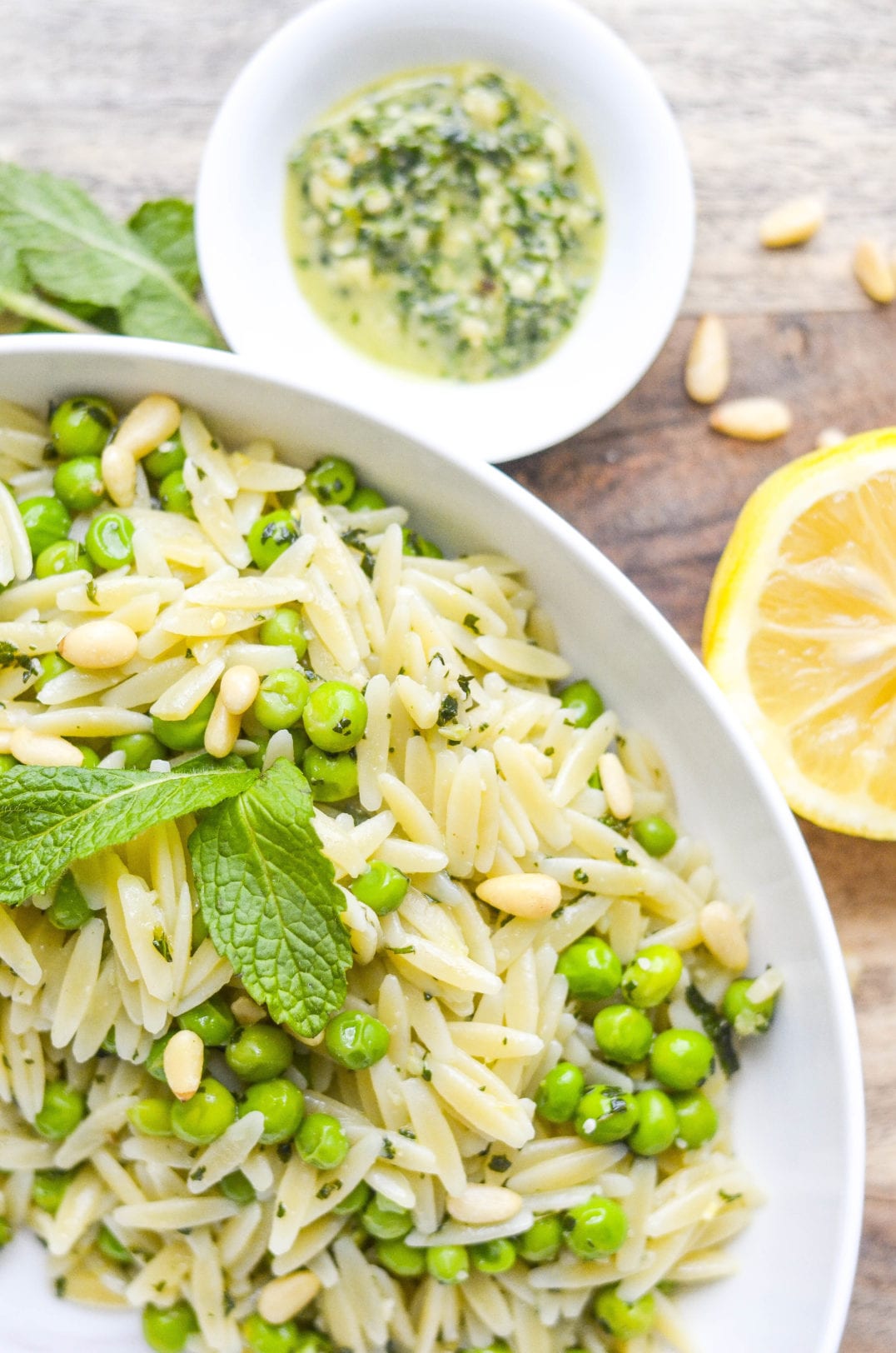 orzo, peas, pine nuts, and mint in a serving bowl and a dish of pesto