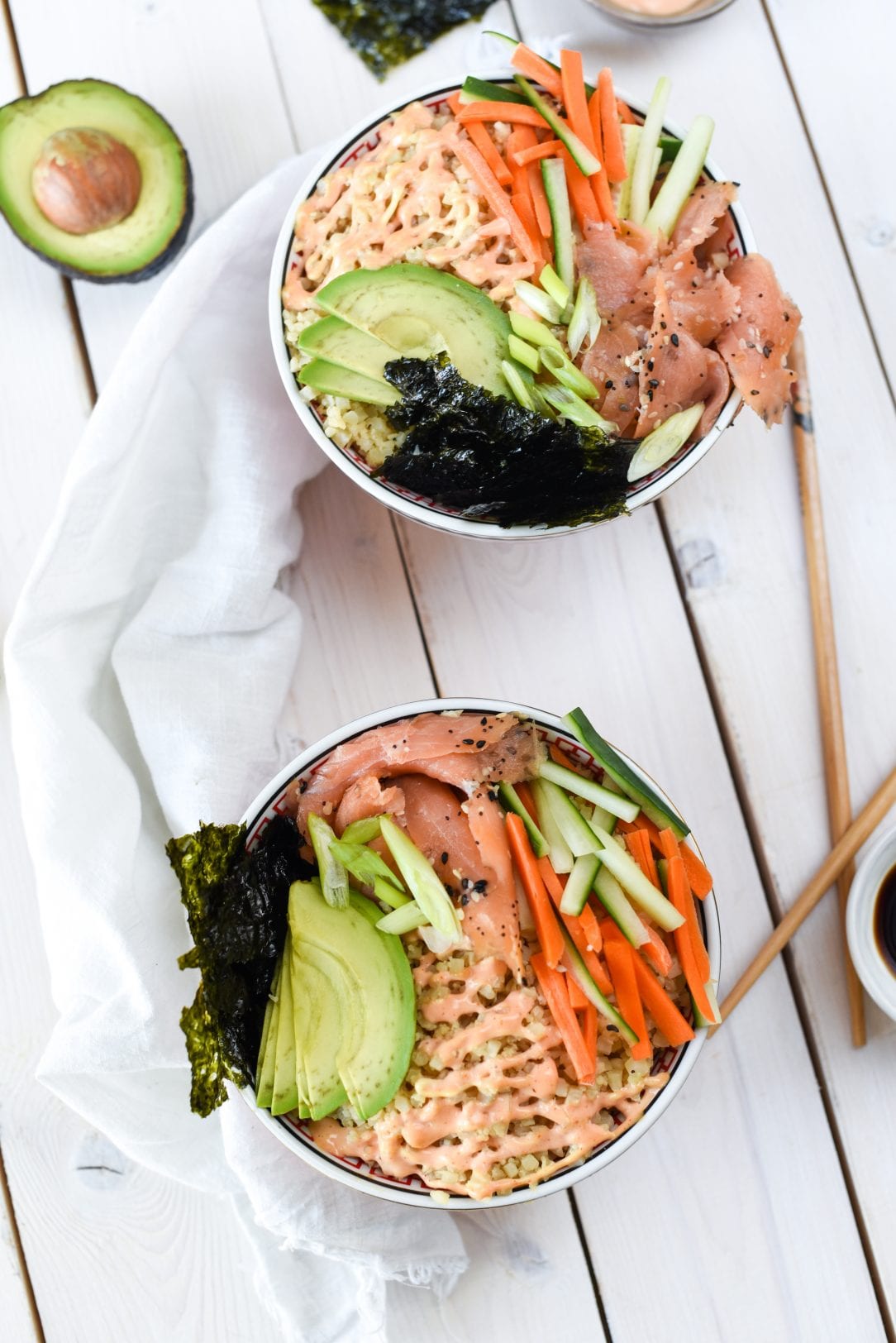 Whole30 Smoked Salmon Sushi Bowl on a table with a small bowl of soy sauce and an open avocado